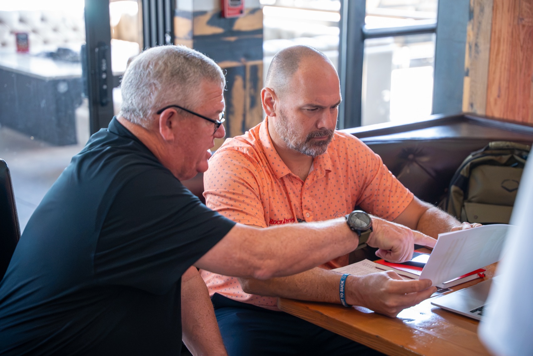 Dave Duff and Kris Maronpot reading invoices together at Rock & Brews